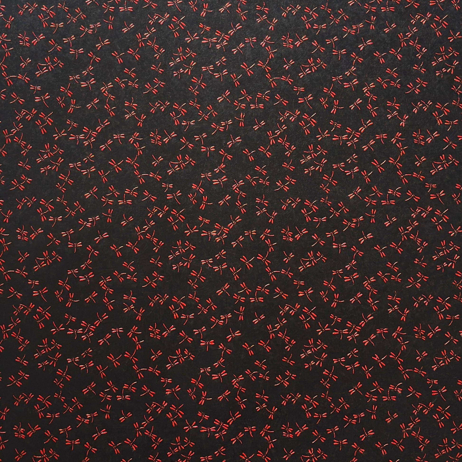 a sheet of Japanese lacquered yuzen paper with black background and little red dragonflies