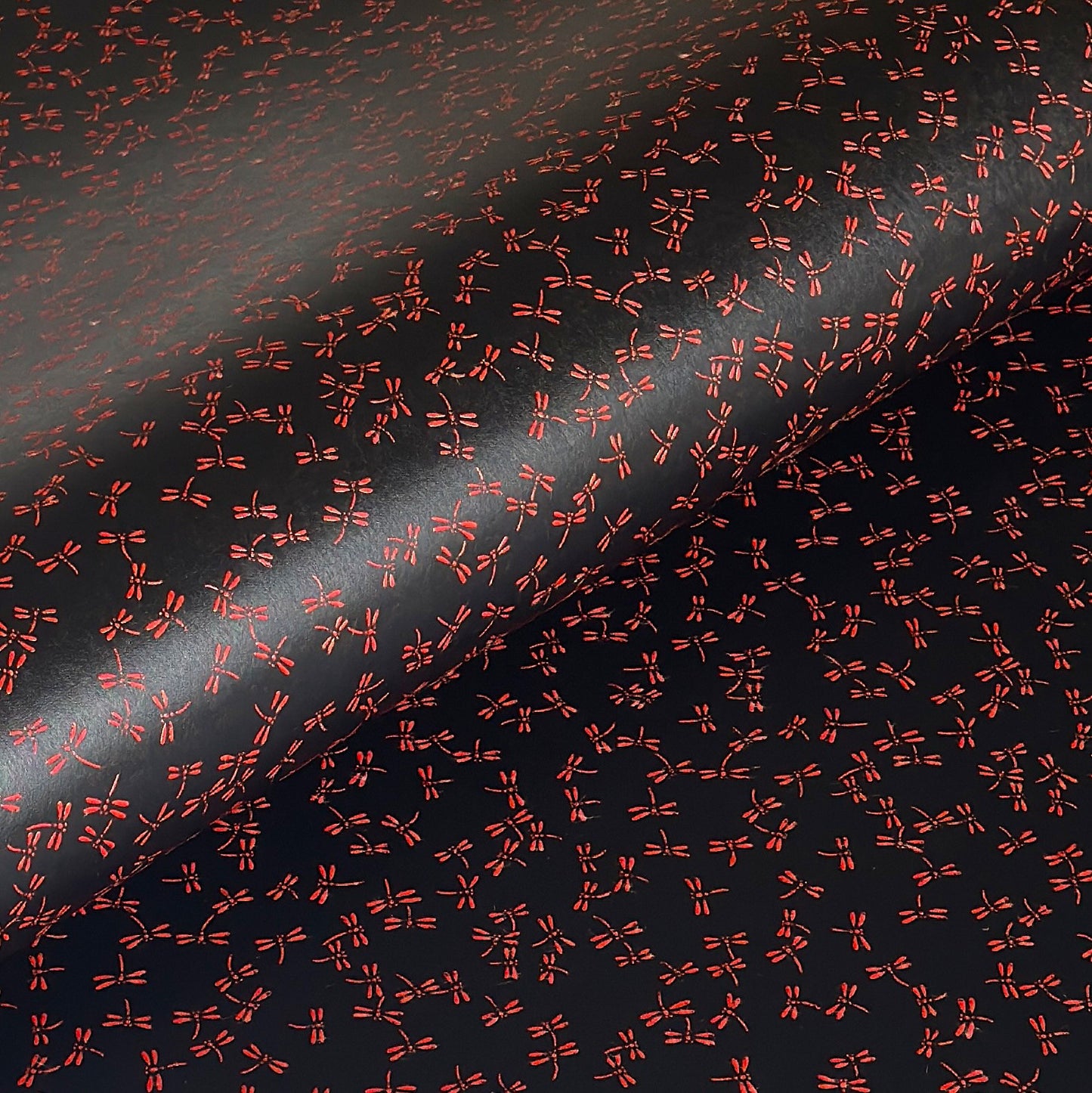 a sheet of Japanese lacquered yuzen paper with black background and little red dragonflies