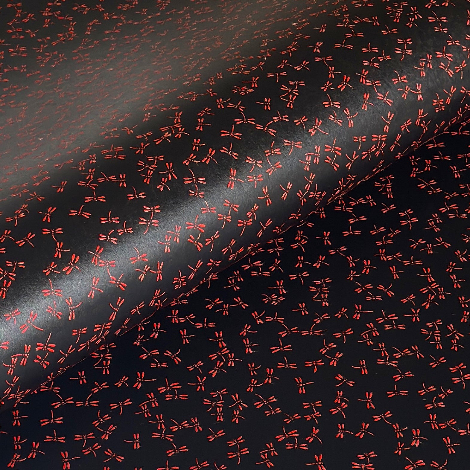 a sheet of Japanese lacquered yuzen paper with black background and little red dragonflies