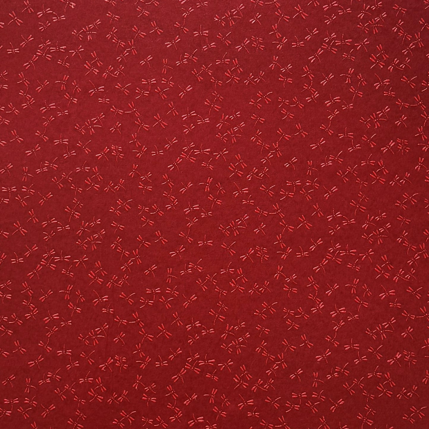 a sheet of Japanese lacquered yuzen paper in bright red background and little red dragonflies