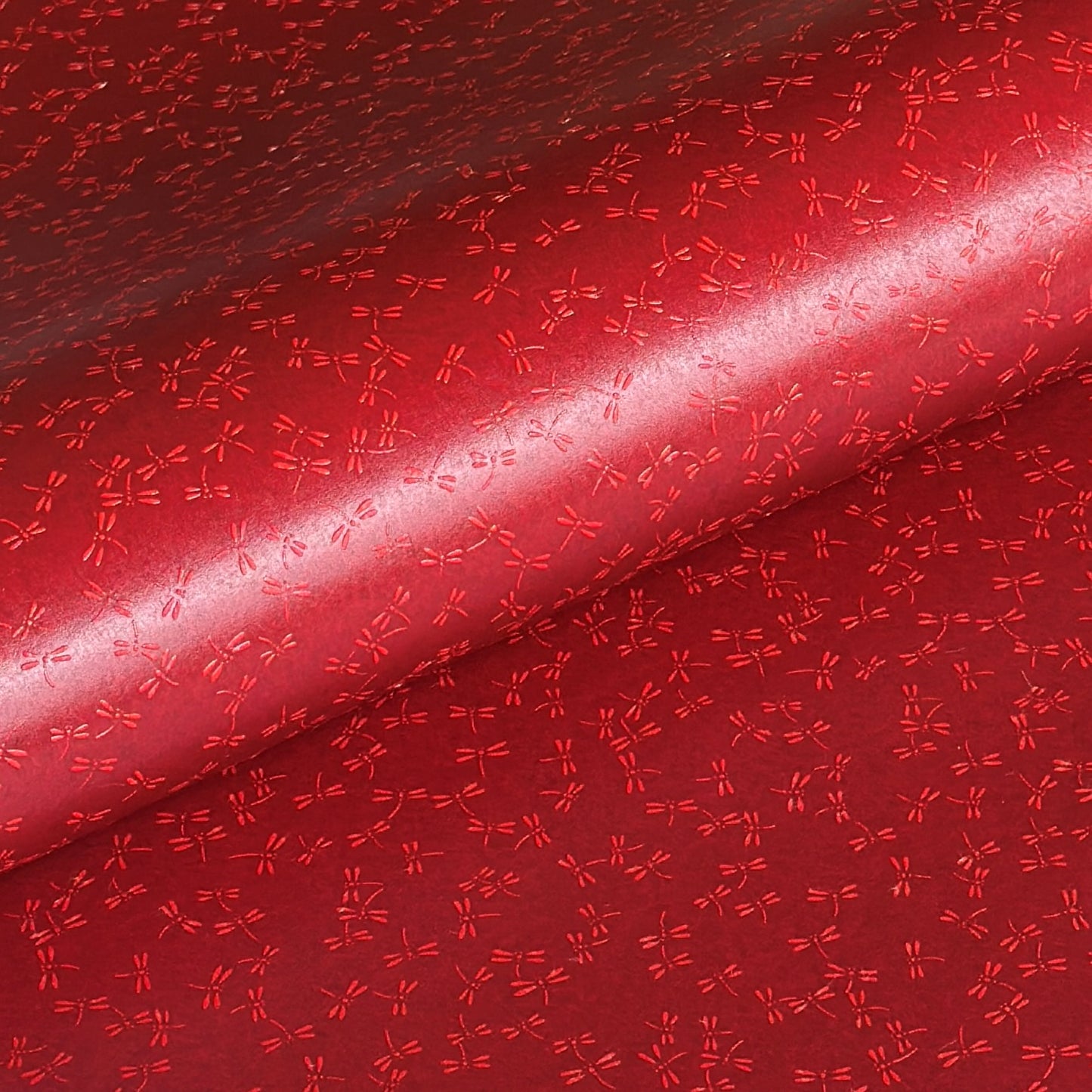 a sheet of Japanese lacquered yuzen paper in bright red background and little red dragonflies
