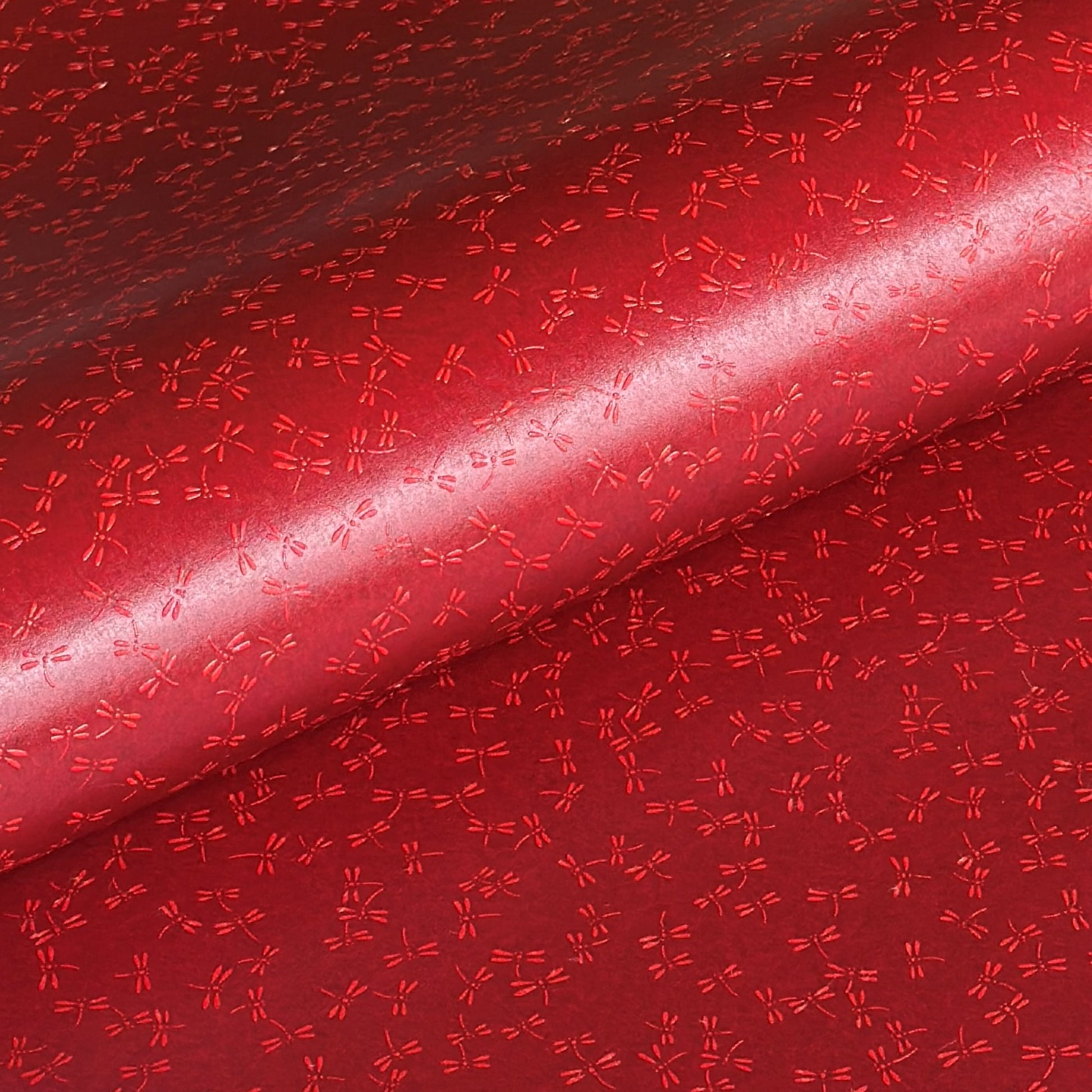 a sheet of Japanese lacquered yuzen paper in bright red background and little red dragonflies