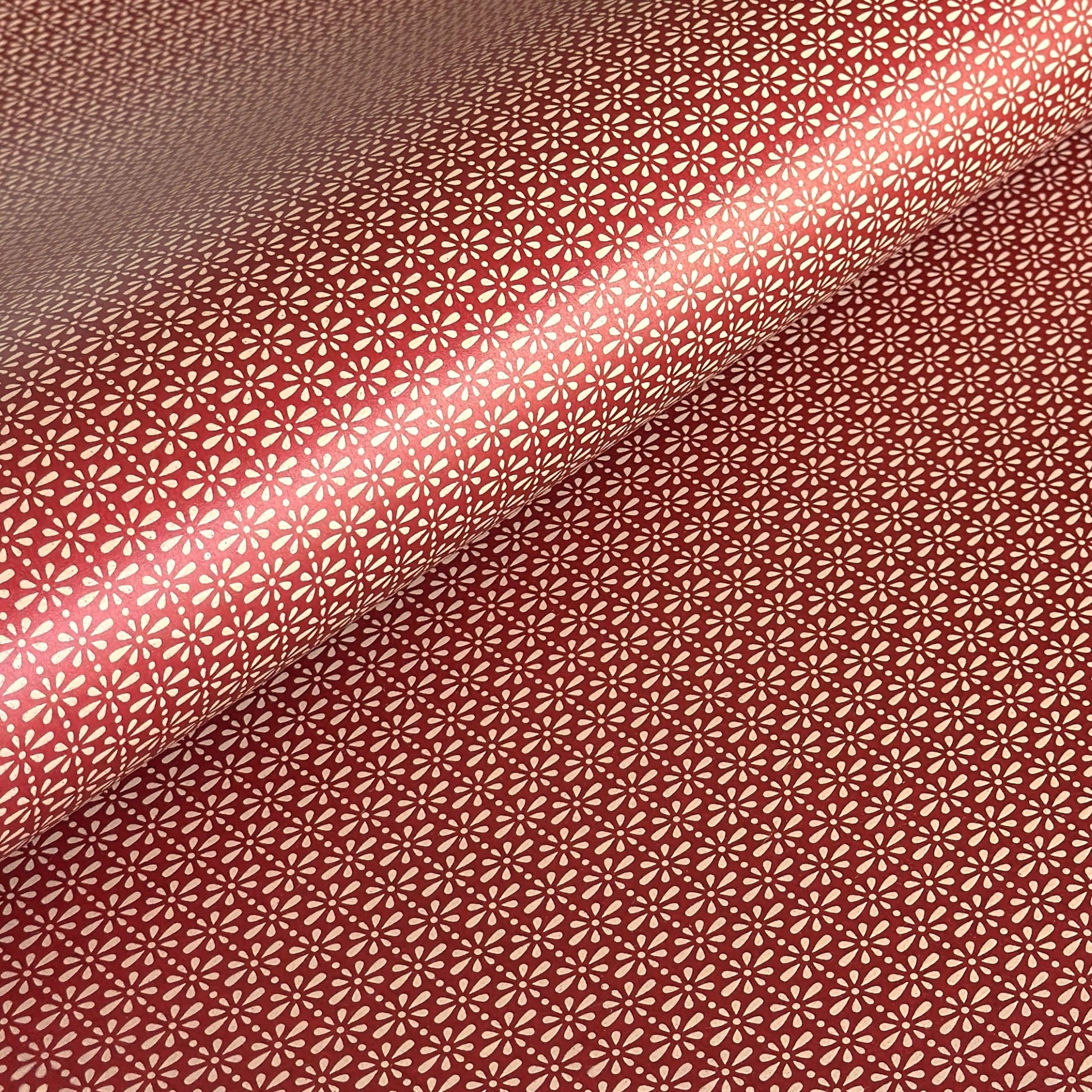 A sheet of Japanese lacquered yuzen paper in red with a repeat geometric flower pattern in cream