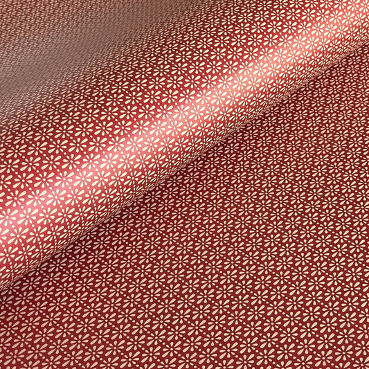 A sheet of Japanese lacquered yuzen paper in red with a repeat geometric flower pattern in cream