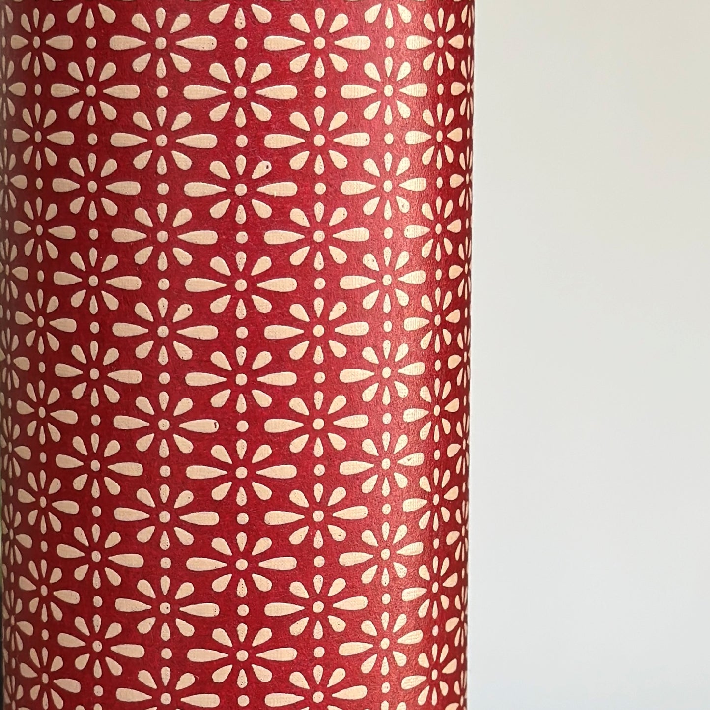 A sheet of Japanese lacquered yuzen paper in red with a repeat geometric flower pattern in cream