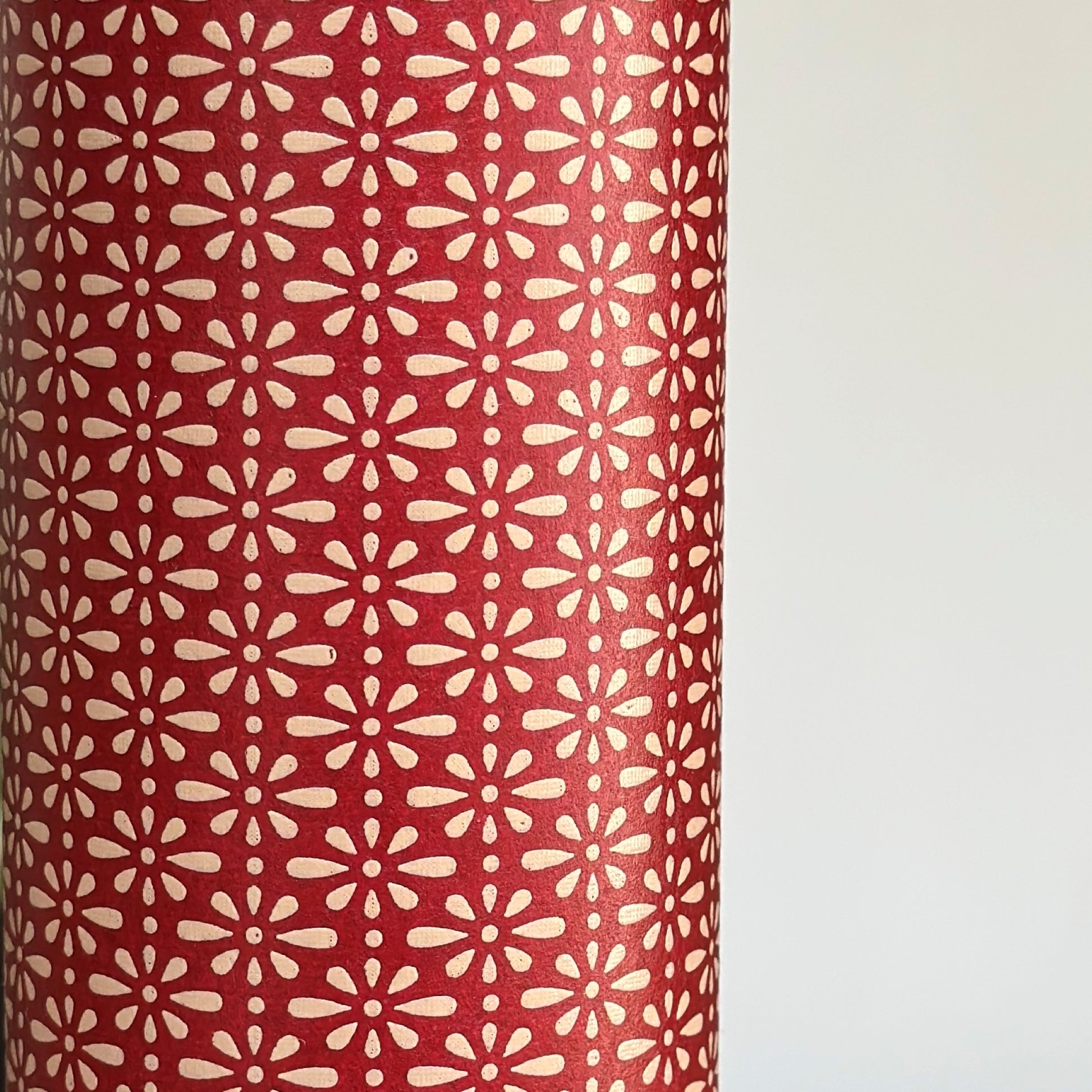 A sheet of Japanese lacquered yuzen paper in red with a repeat geometric flower pattern in cream
