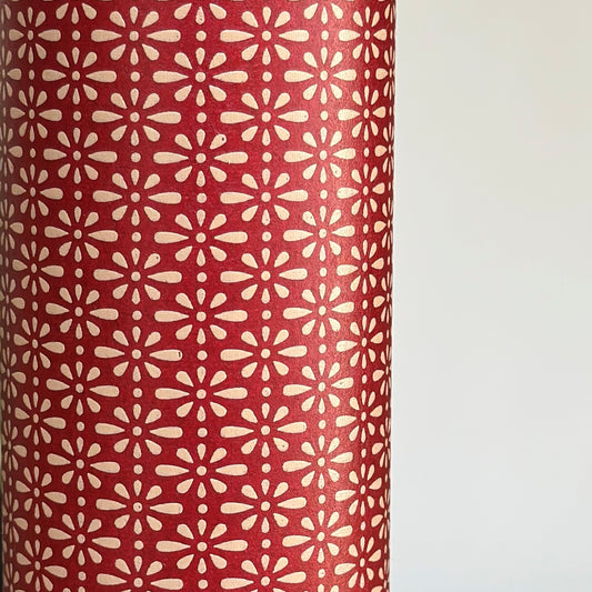 A sheet of Japanese lacquered yuzen paper in red with a repeat geometric flower pattern in cream
