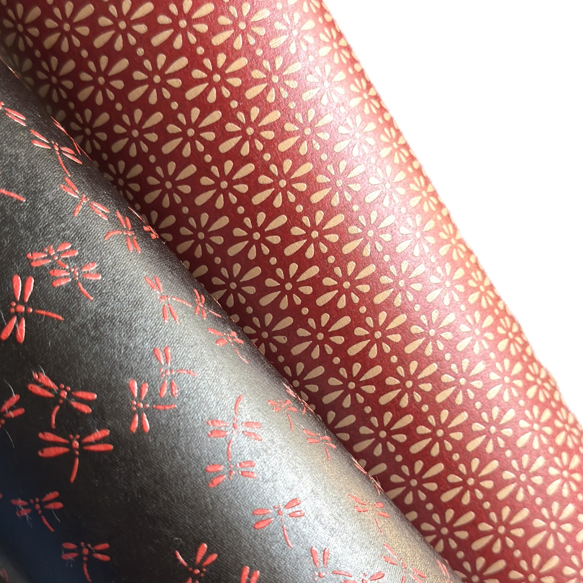 A sheet of Japanese lacquered yuzen paper in red with a repeat geometric flower pattern in cream