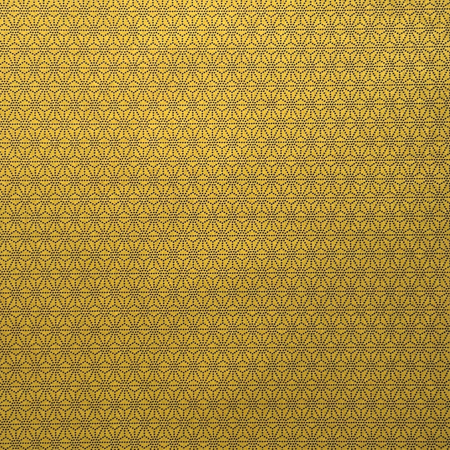 a sheet of Japanese lacquered yuzen paper with a mustard yellow background and a geometric dotted star pattern in black