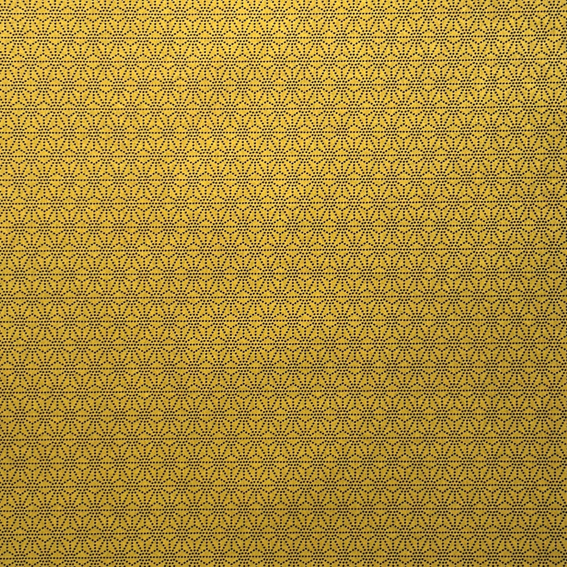 a sheet of Japanese lacquered yuzen paper with a mustard yellow background and a geometric dotted star pattern in black