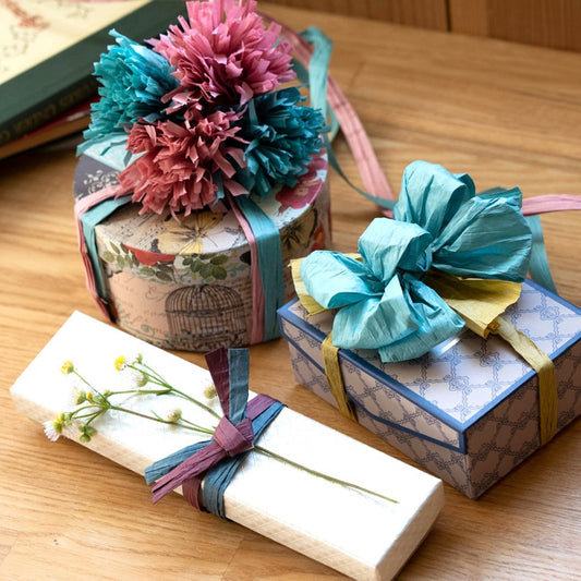 present wrapped with Japanese paper string as flat, bows and pom poms 