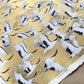 a sheet of Japanese Sogara yuzen paper with an image of white and black flying cranes on a gold background.