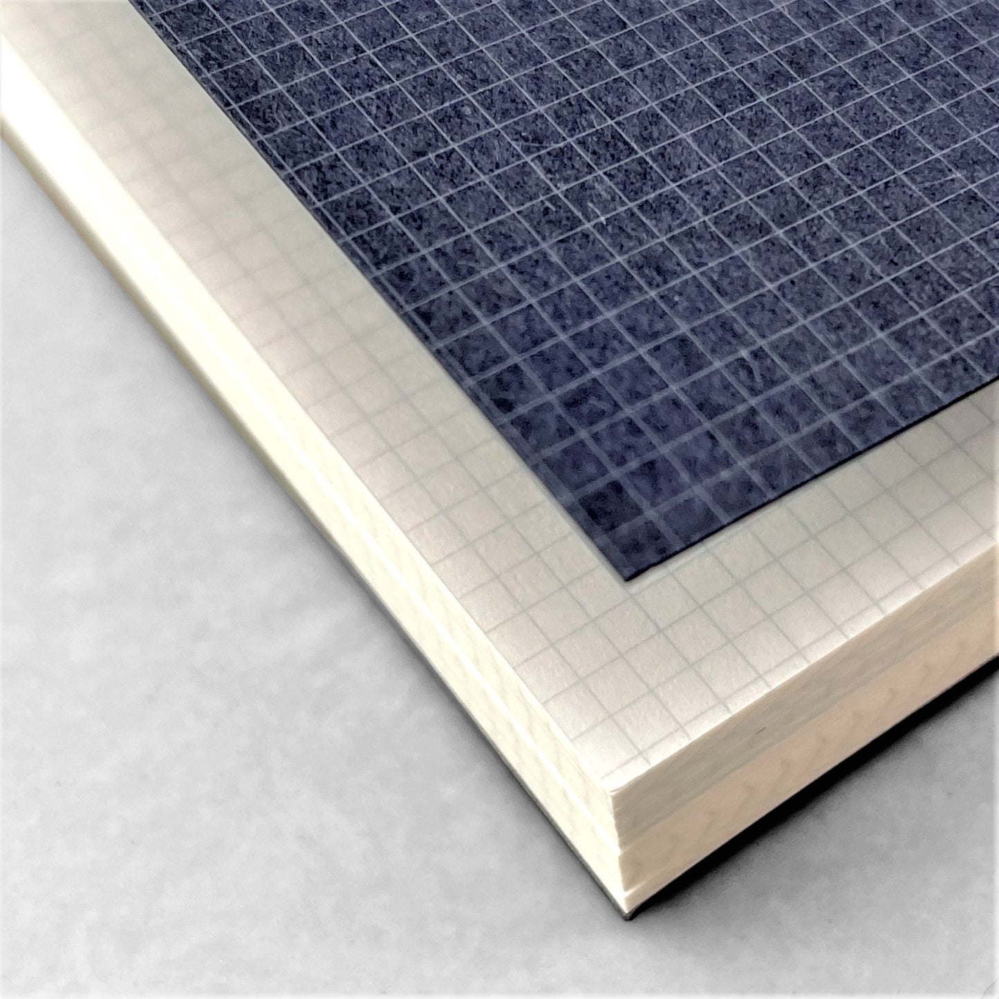 A5 softcover notebook with grid pages. The cover is dark blue with a white grid, black spine and branding in silver. By Japanese brand Kleid