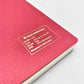 A5 soft cover notebook, cover is red with a small white grid pattern by Japanese brand Kleid