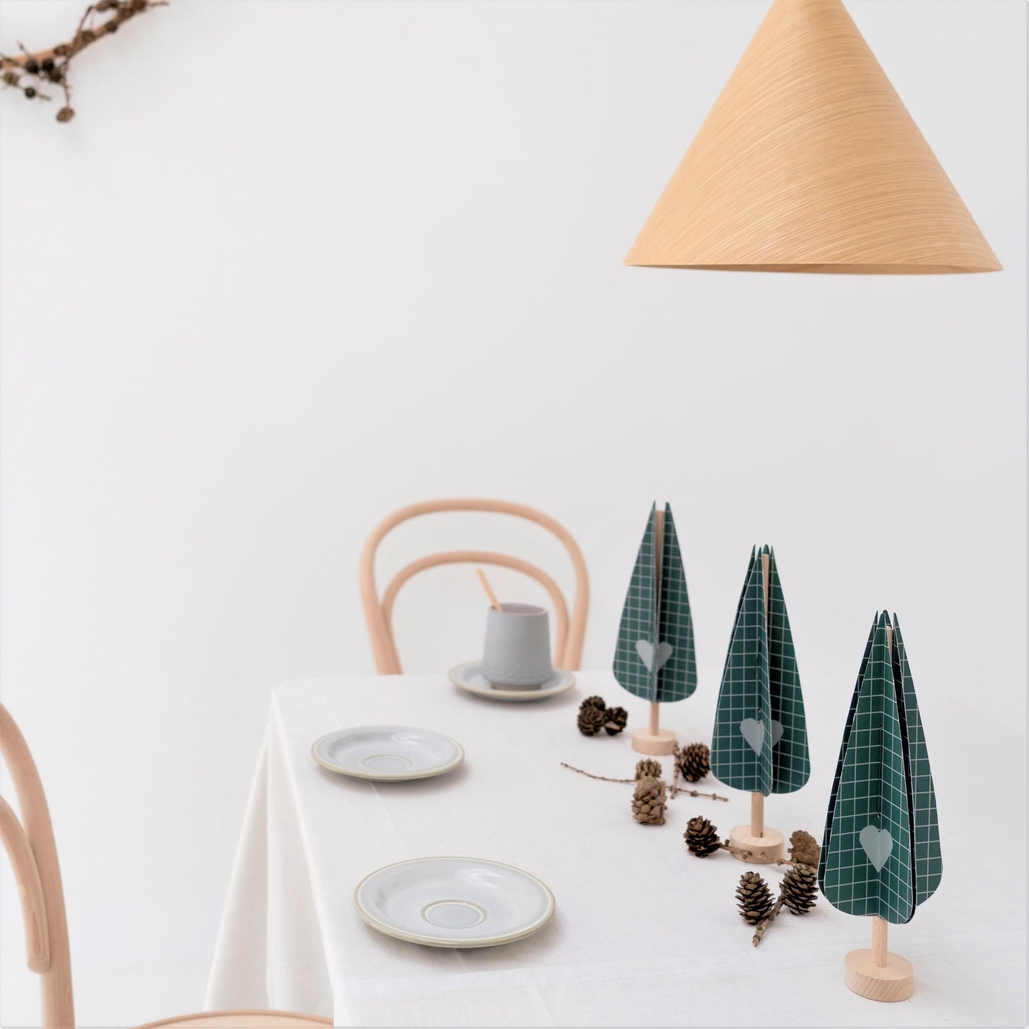 paper craft kit of a dark green cypress tree by Jurianne Matter, pictured on a table