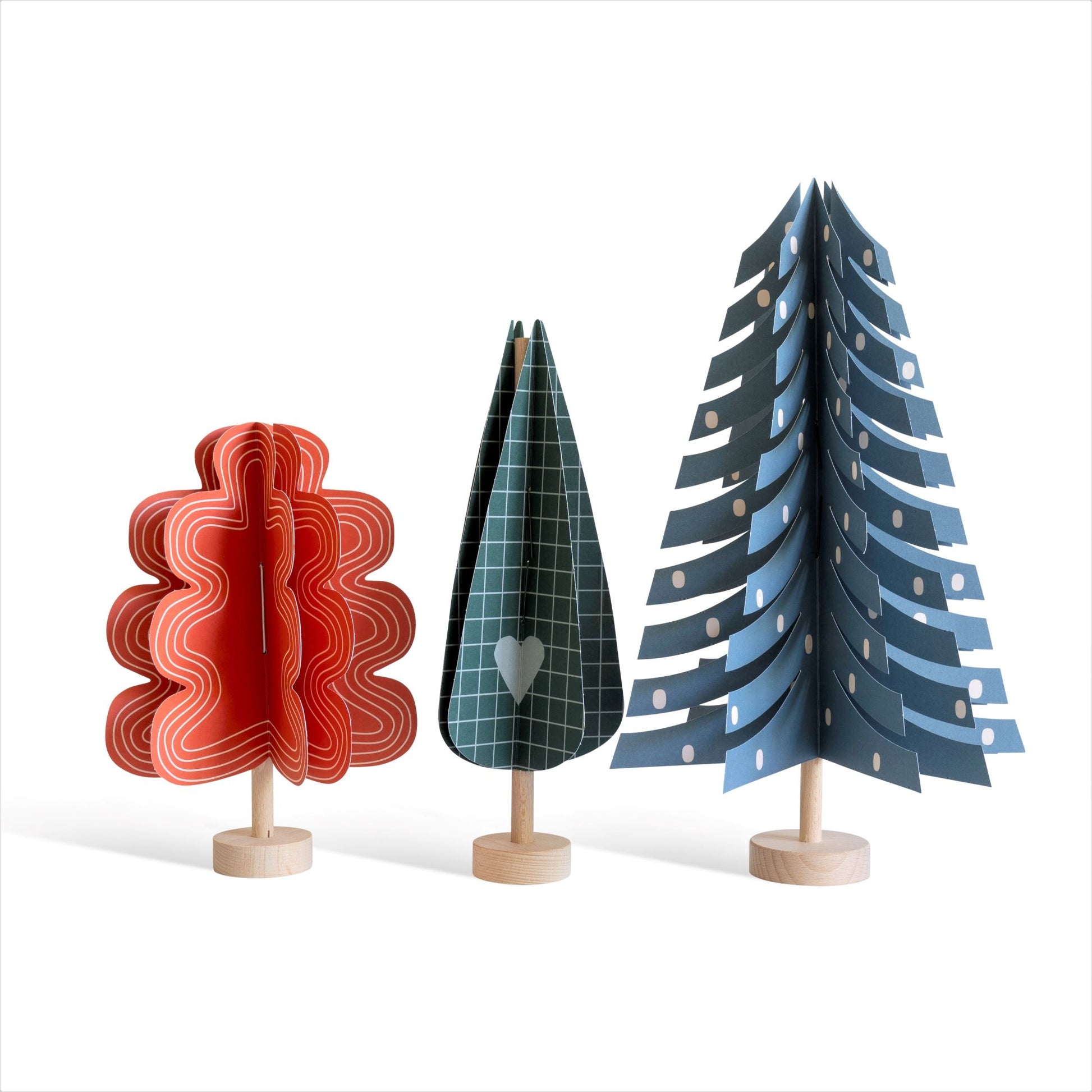 paper craft kit of a dark green cypress tree by Jurianne Matter, pictured with a red oak paper tree and a blue fir paper tree
