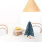 A blue paper fir tree decoration by Jurianne Matter., pictured on a table