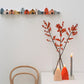 set of 12 colourful paper houses by Jurianne Matter, pictured in a straight line as a wall decoration