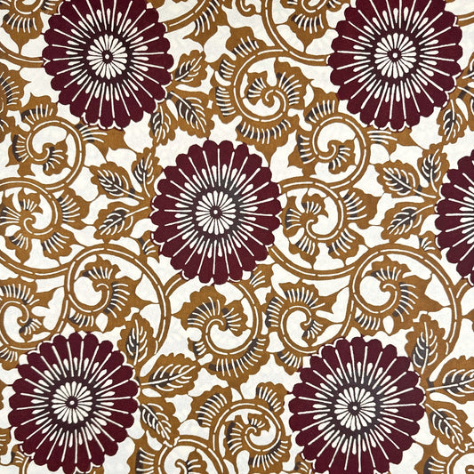 Japanese stencil-dyed paper with a large stylised floral pattern of a chrysanthemum in deep brown and tan.