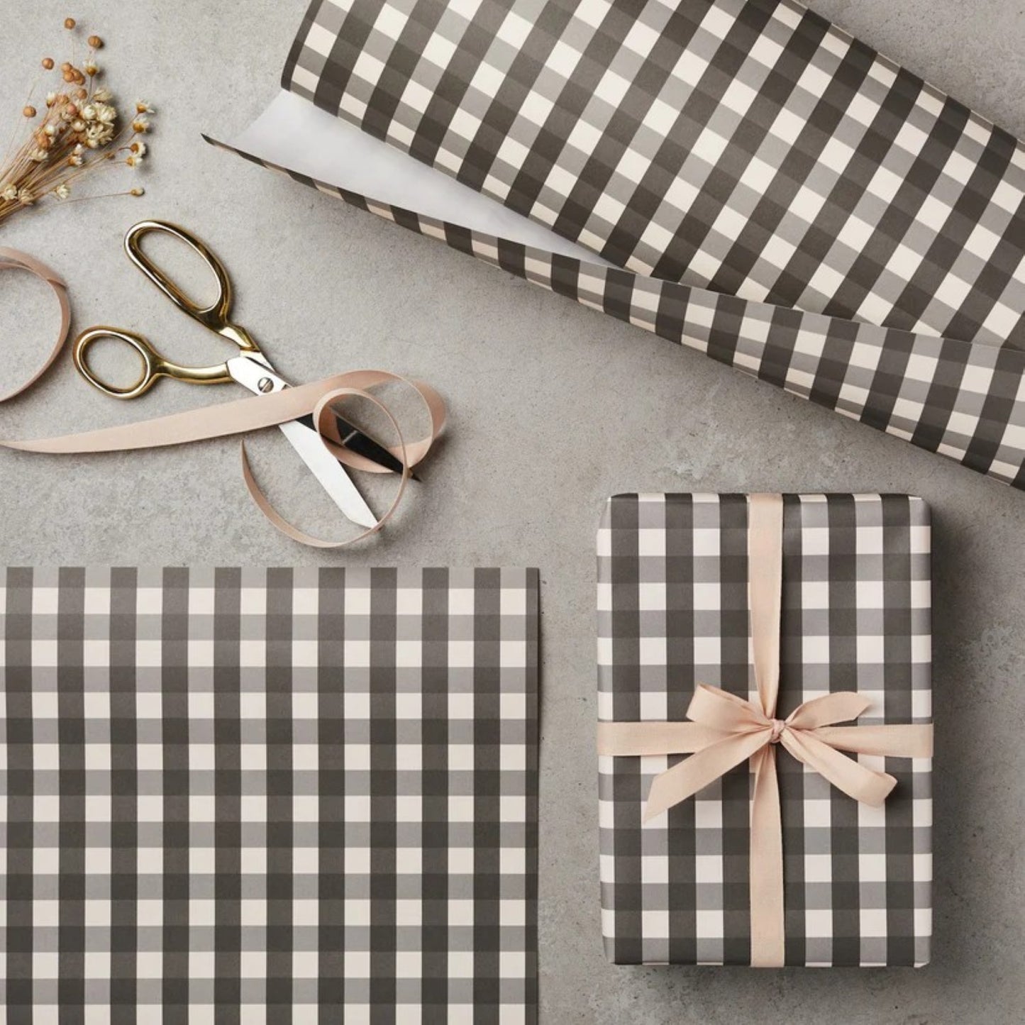 a sheet of wrapping paper with a black and white gingham pattern. Pictured wrapped