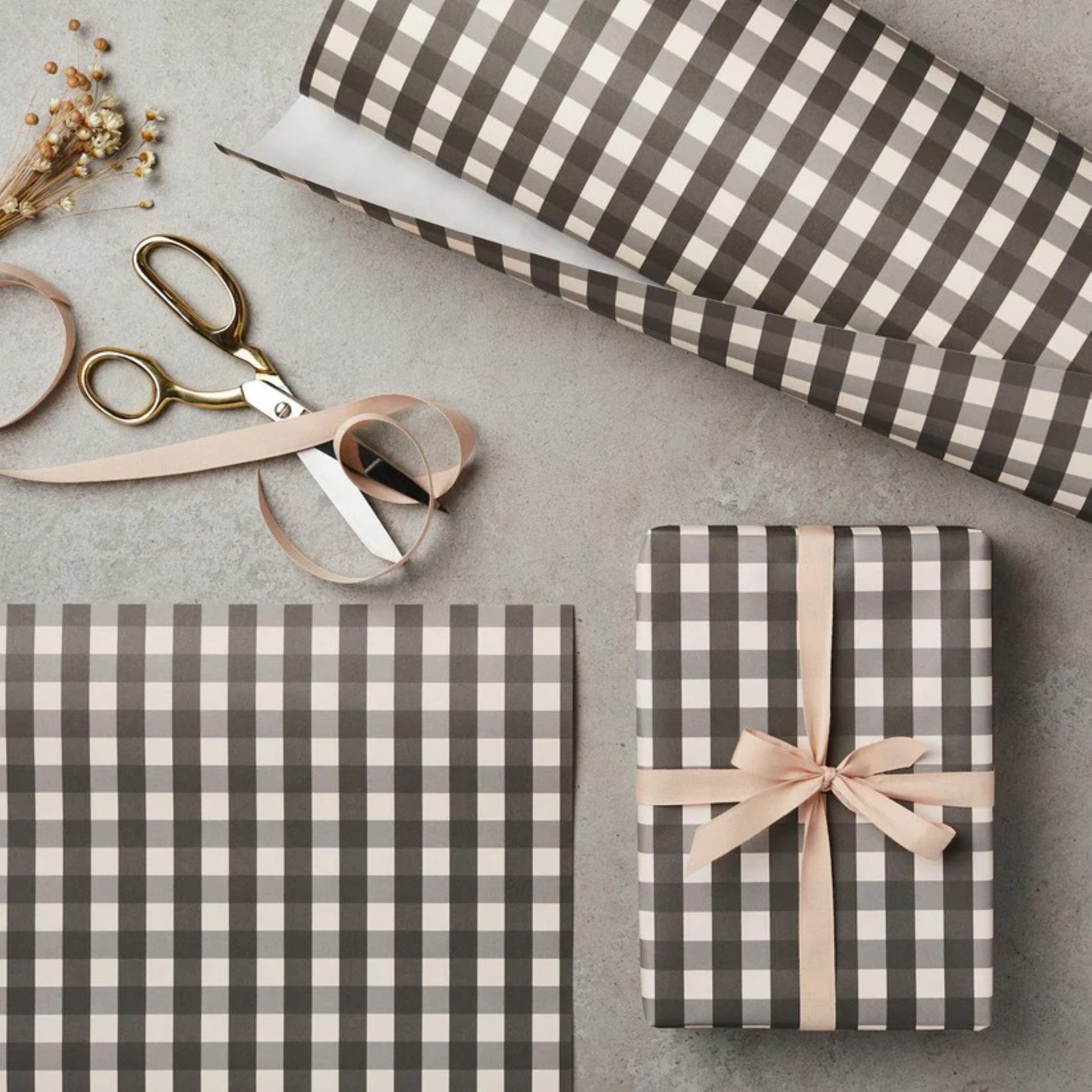 a sheet of wrapping paper with a black and white gingham pattern. Pictured wrapped