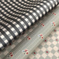 a sheet of wrapping paper with a black and white gingham pattern. Pictured with a floral pattern