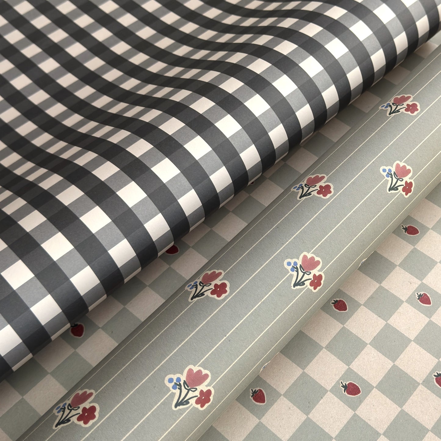 a sheet of wrapping paper with a black and white gingham pattern. Pictured with a floral pattern