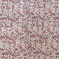 a sheet of wrapping paper with a pretty floral small scale rose design in pink and purple.