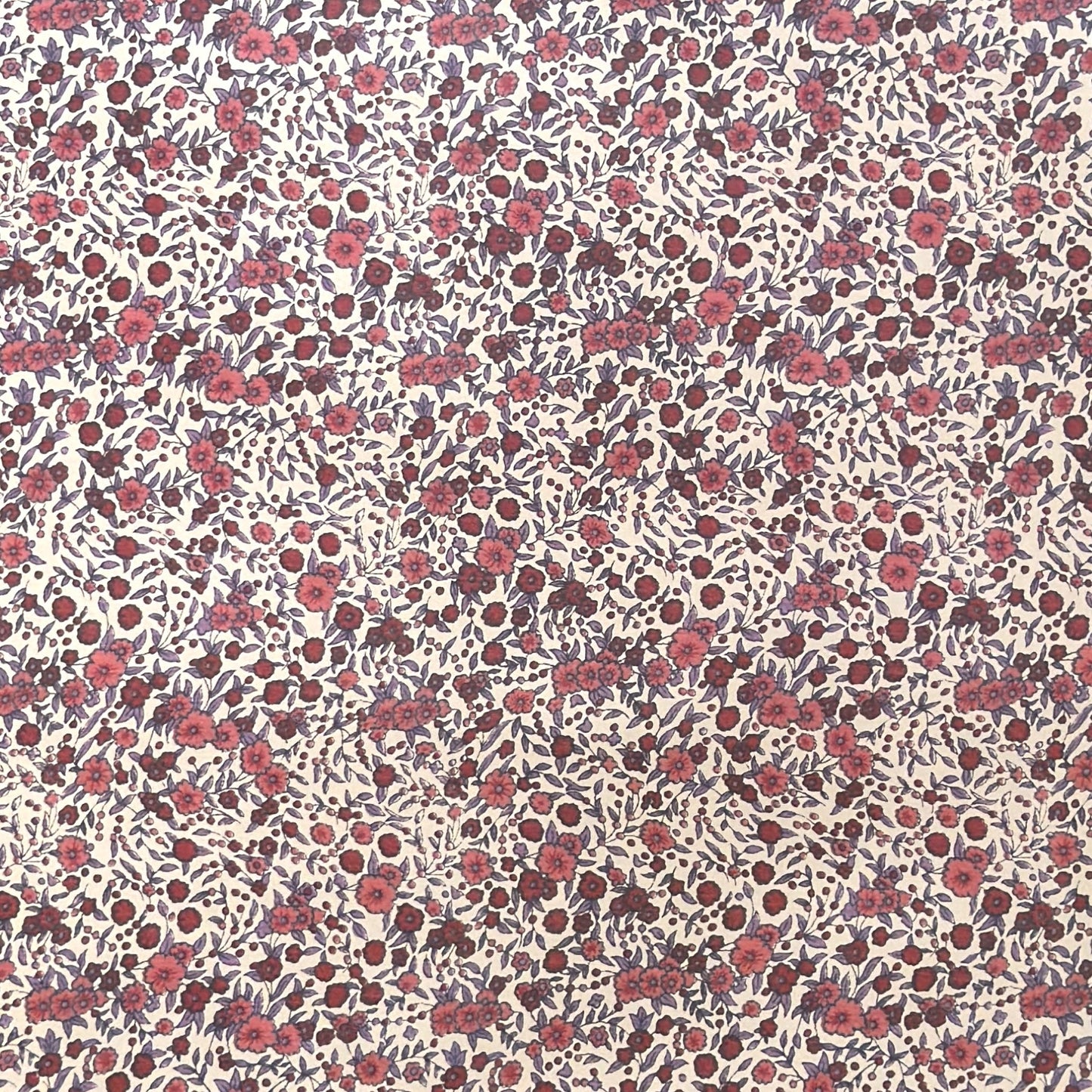 a sheet of wrapping paper with a pretty floral small scale rose design in pink and purple.