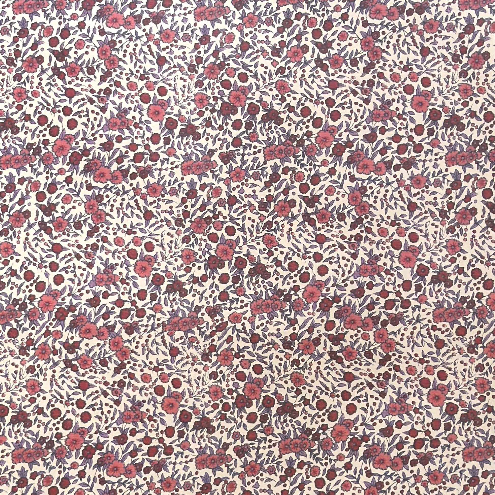 a sheet of wrapping paper with a pretty floral small scale rose design in pink and purple.