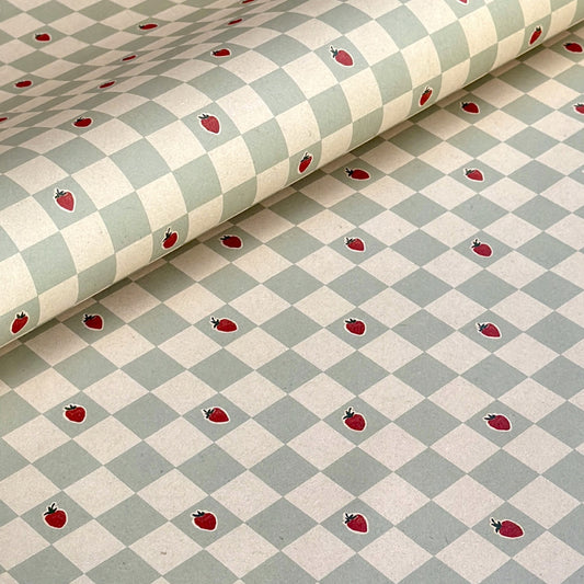a sheet of wrapping paper with a soft green and cream checkered pattern with vintage style strawberries