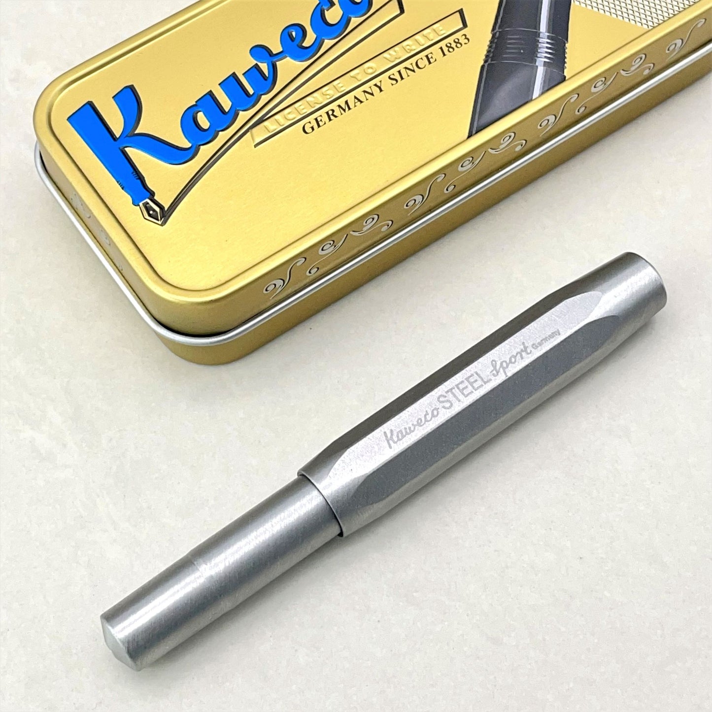 Kaweco Steel Sport fountain pen, pictured with branded tin presentation box
