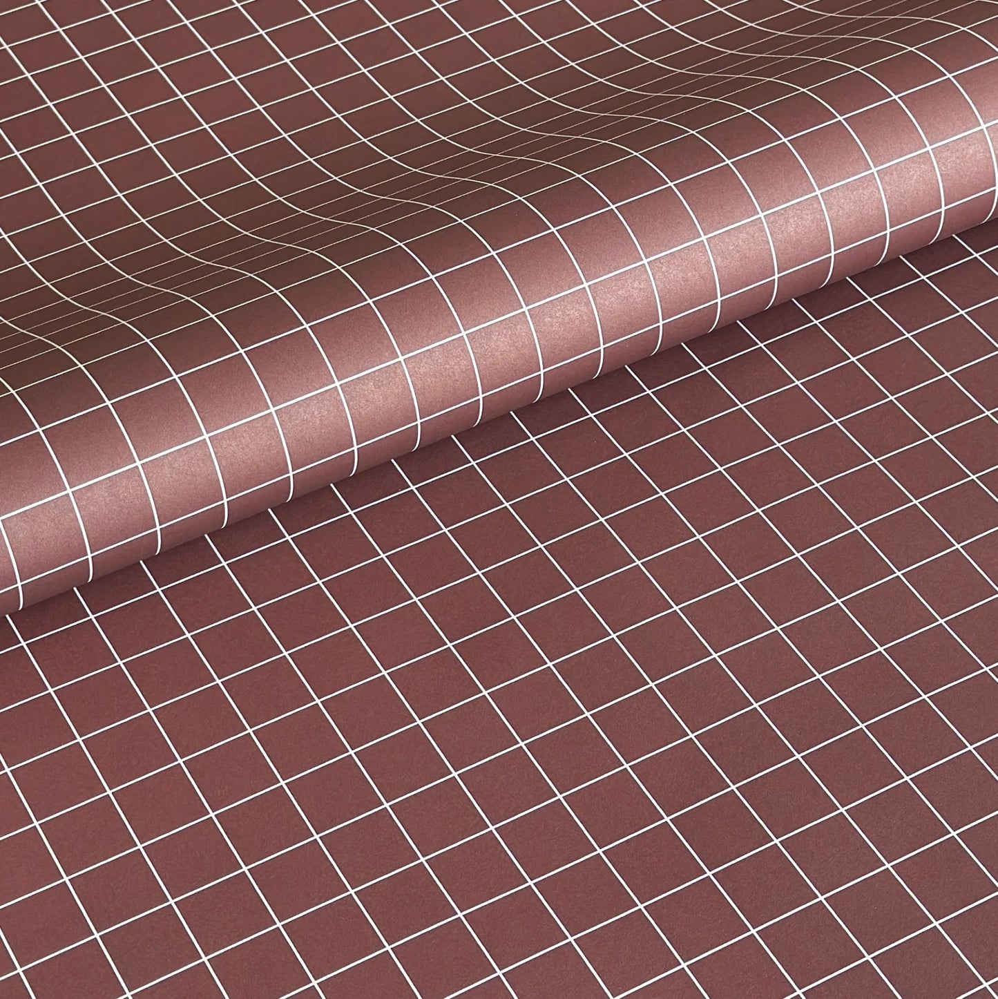 a sheet of wrapping paper in brown with a simple white grid pattern
