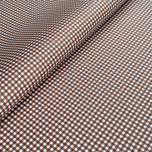 a sheet of wrapping paper with a small scale gingham pattern in russet brown