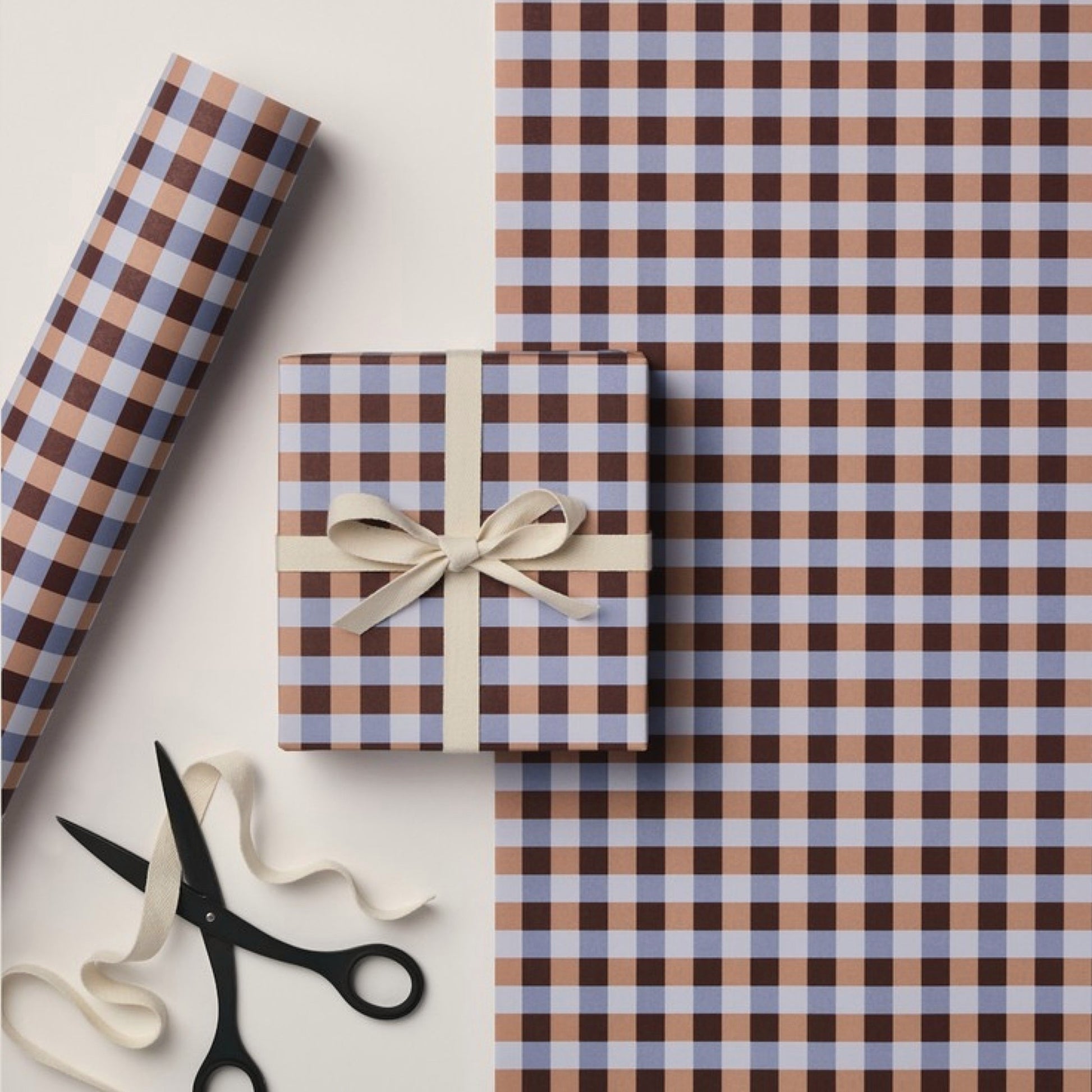 a sheet of wrapping paper with a gingham pattern in brown, beige and light blue