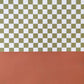 a sheet of wrapping paper with a green checkered pattern on the top half and plain cinnamon brown on the bottom