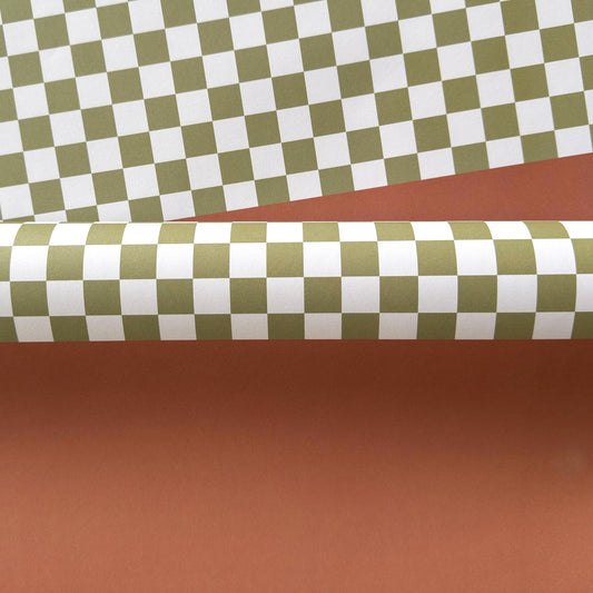 a sheet of wrapping paper with a green checkered pattern on the top half and plain cinnamon brown on the bottom
