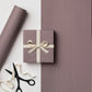 a sheet of wrapping paper with a narrow stripe design in dark brown and cream