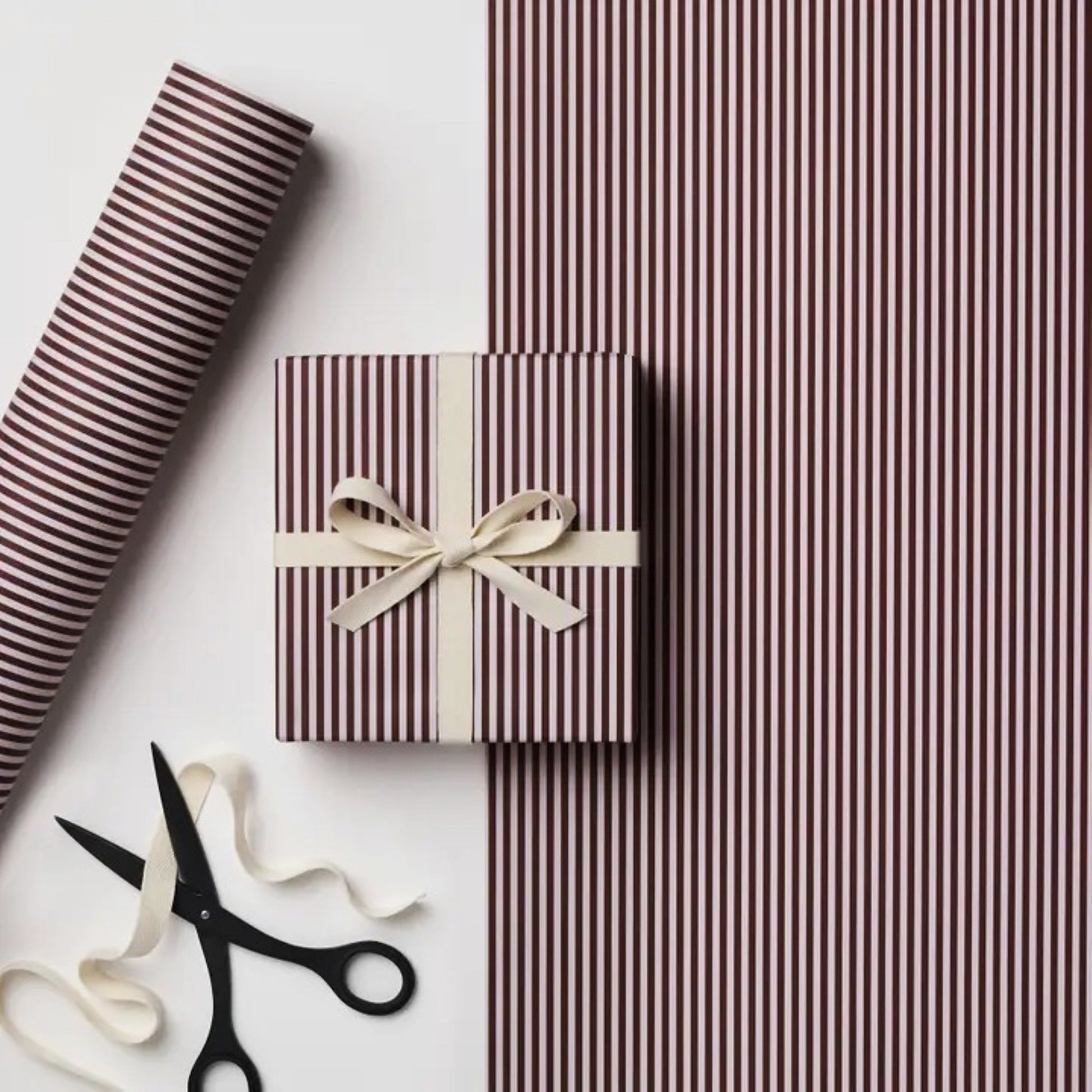 a sheet of wrapping paper with a narrow stripe design in dark brown and cream
