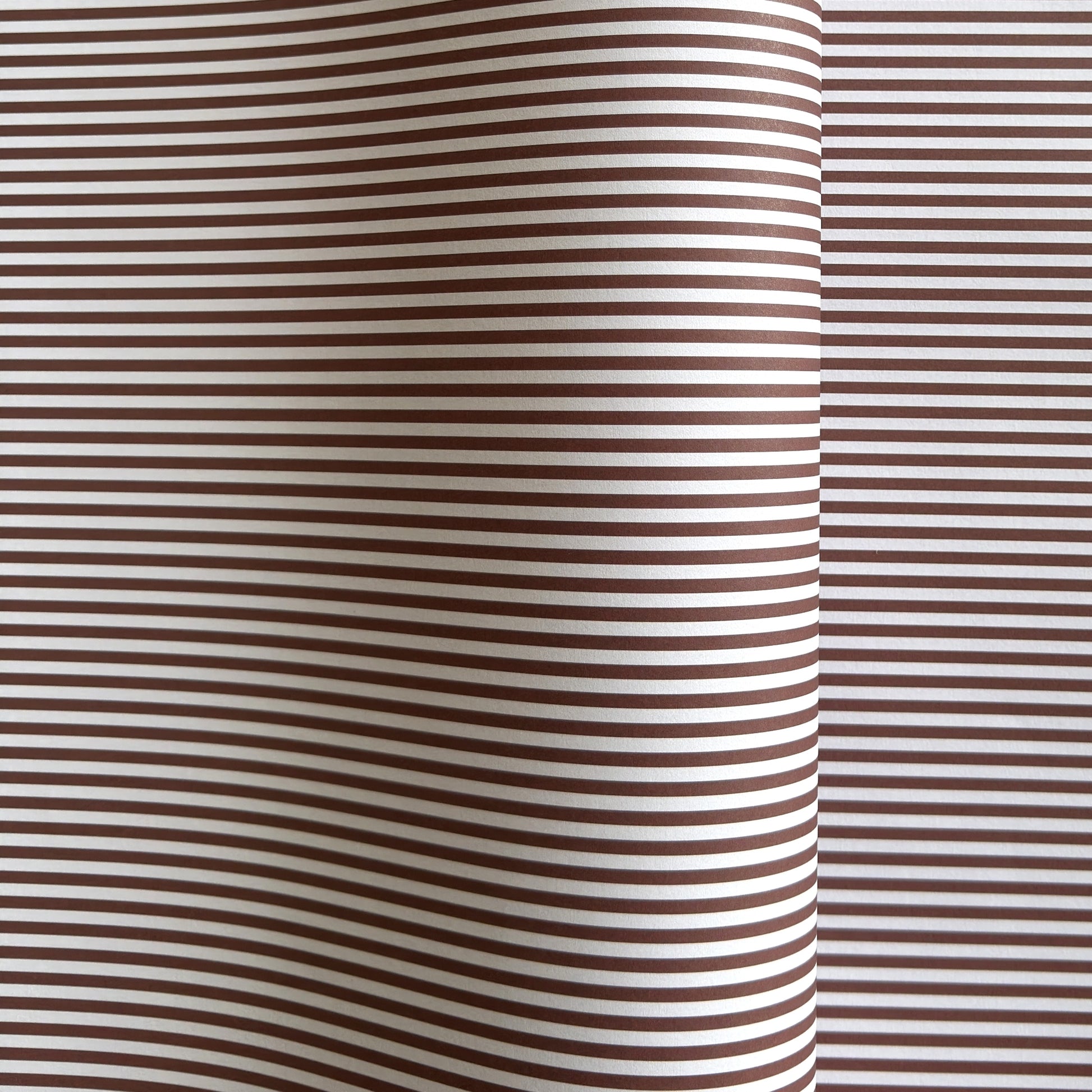 a sheet of wrapping paper with a narrow stripe design in dark brown and cream