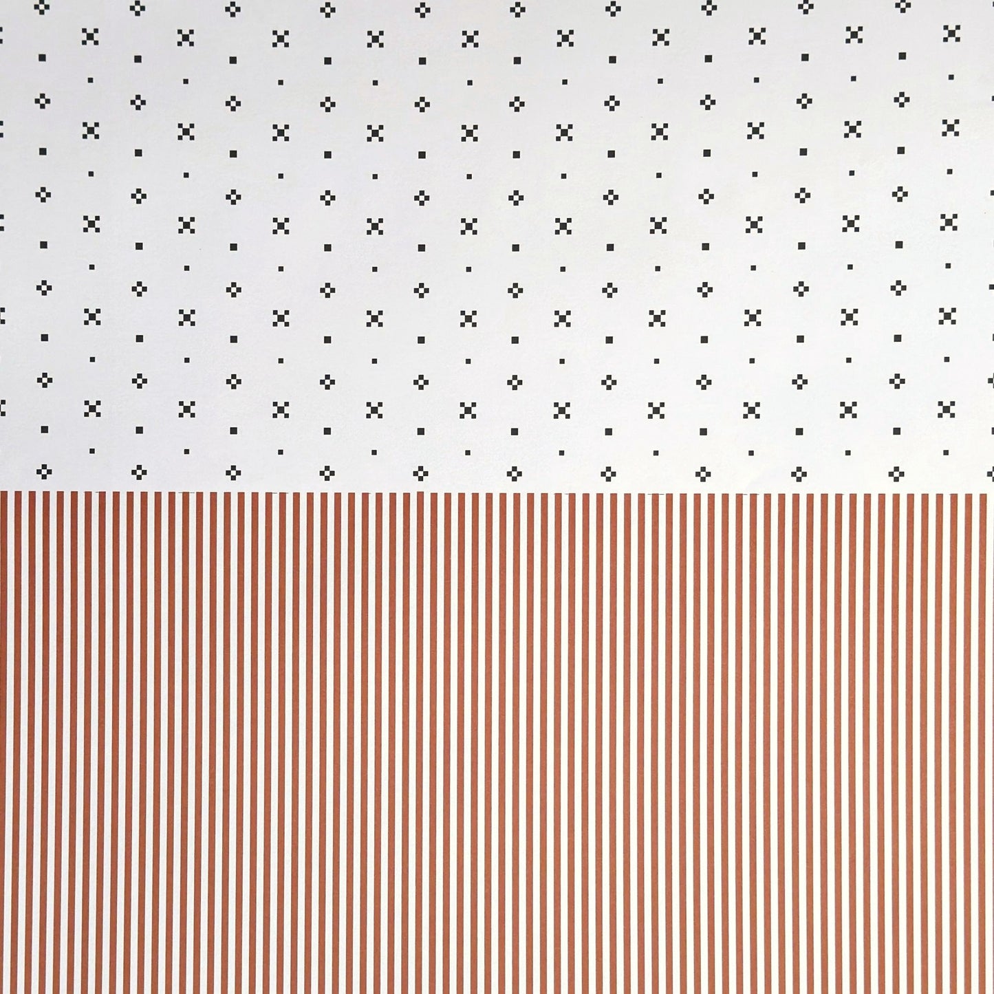 a sheet of wrapping paper with a split design, the top half has little black tile design on white and the bottom half a narrow stripe in cinnamon and white.