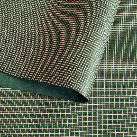 a sheet of Nepalese lokta paper with a lime green and pink grid pattern on dark green handmade paper