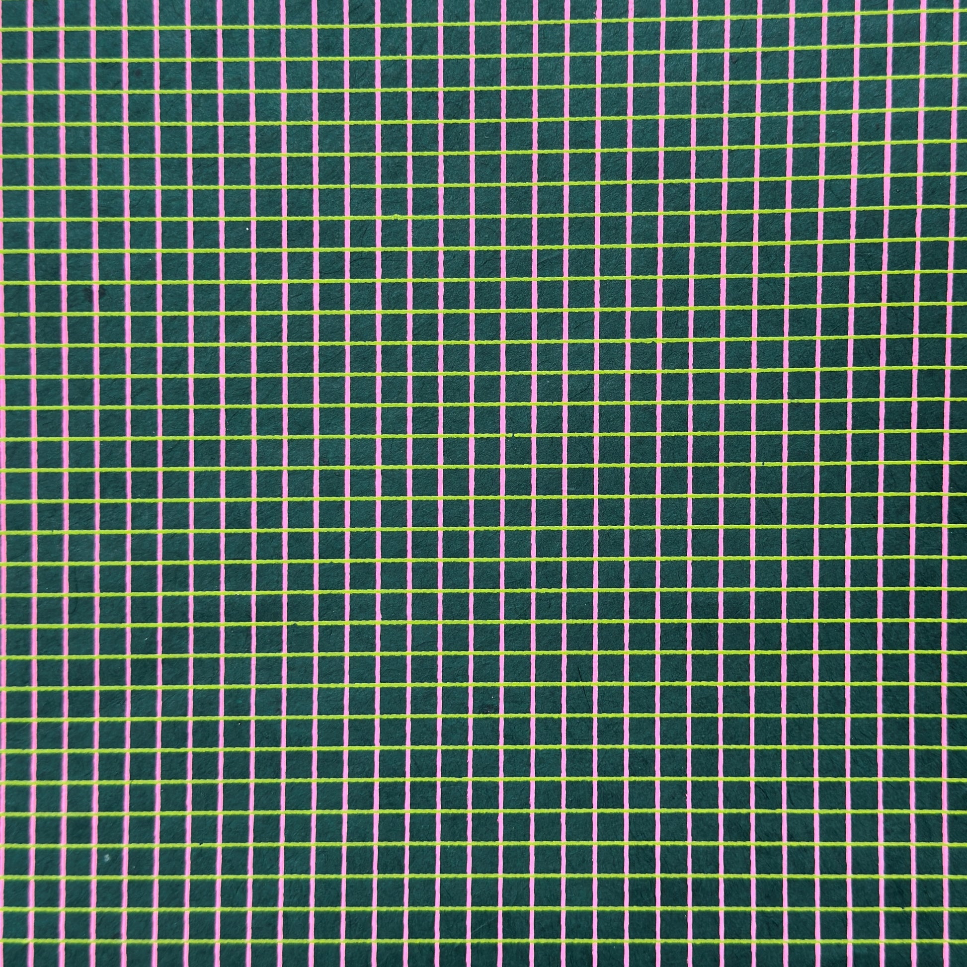a sheet of Nepalese lokta paper with a lime green and pink grid pattern on dark green handmade paper. Close up