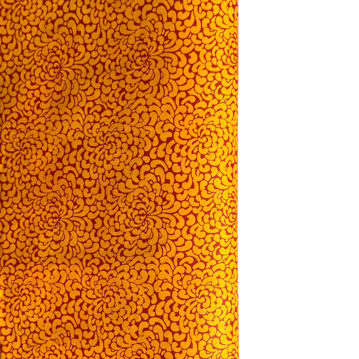 a sheet of screen printed Nepalese lokta paper with a repeat floral design in dark orange on an amber yellow lokta paper 