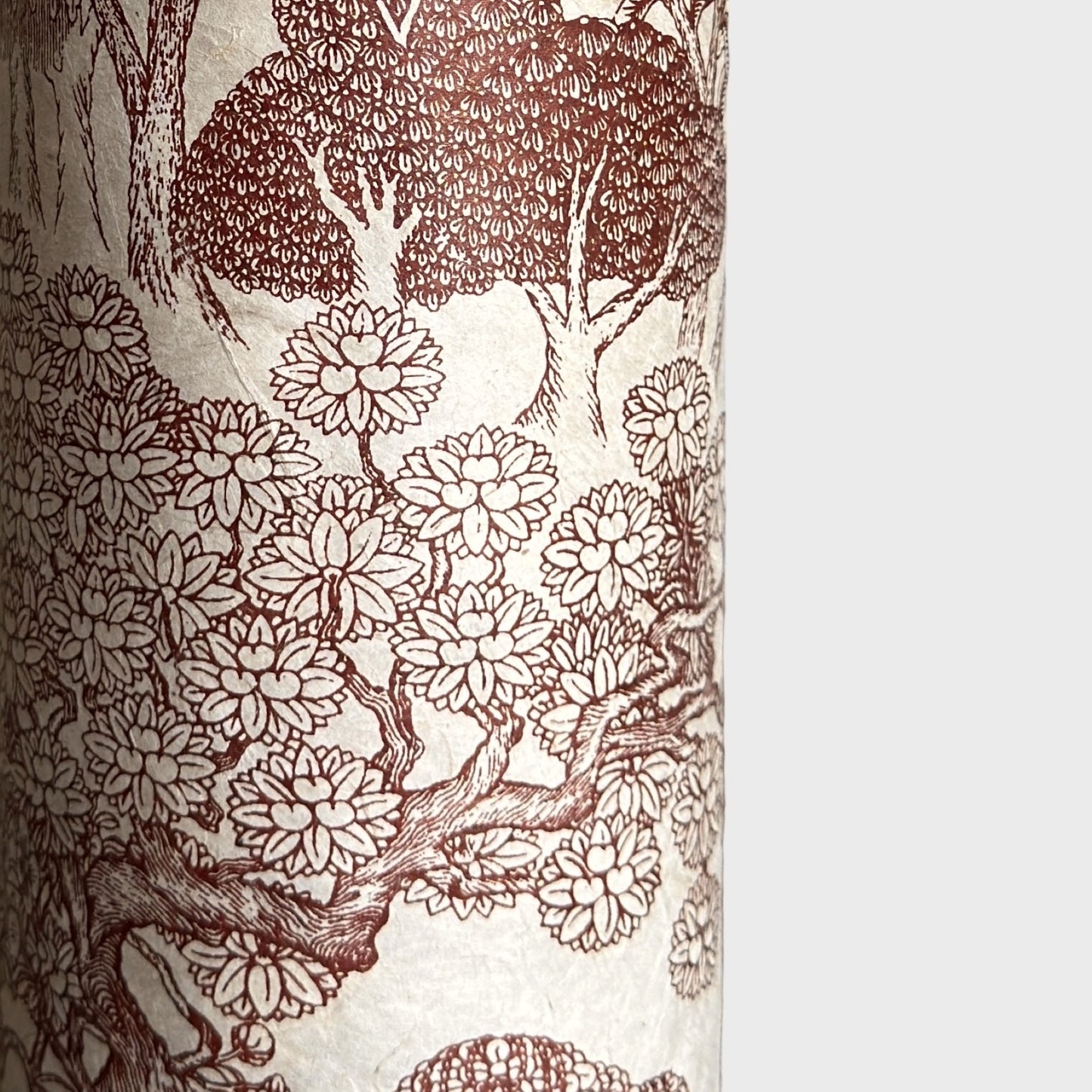 A sheet of Nepalese handprinted Lokta paper with a detailed pattern of trees and flowers in sepia on an ecru base.