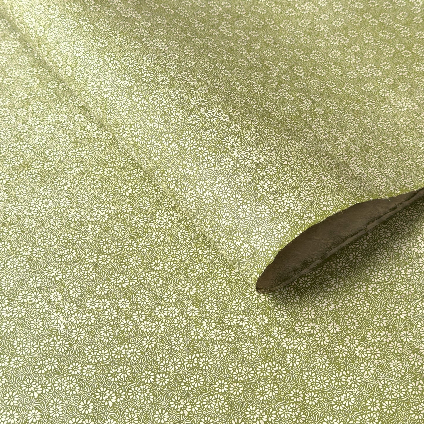Nepalese handmade decorative lokta paper sheet with a white ditsy floral design screen printed on a green lokta paper.