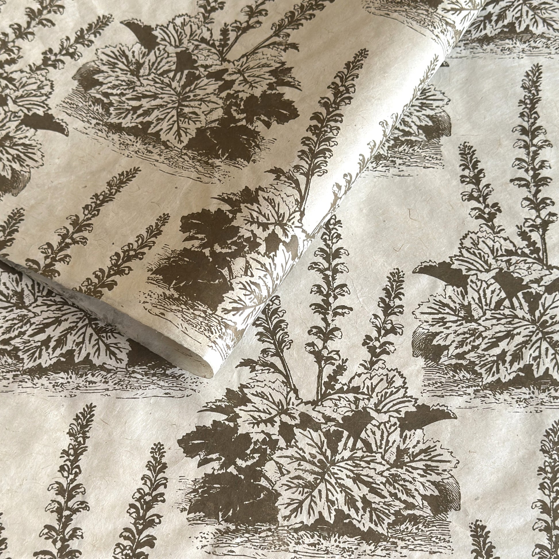 Nepalese handmade decorative lokta paper sheet with a Toile de Jouy style pattern of an agapanthus flower is dark moss screen printed on an ivory lokta paper.
