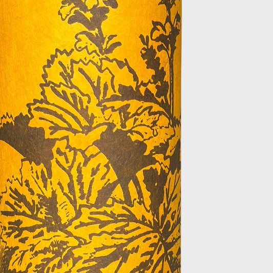 A Toile de Jouy style drawing of an agapanthus in brown screen-printed by hand on mustard yellow lokta paper. close up