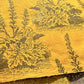 A Toile de Jouy style drawing of an agapanthus in brown screen-printed by hand on mustard yellow lokta paper.