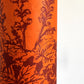 Nepalese handmade decorative lokta paper sheet with a Toile de Jouy style pattern of an agapanthus flower in burgundy screen printed on an orange lokta paper